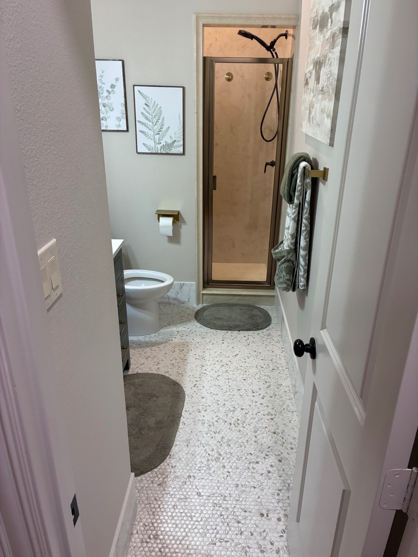 Renovated bathroom with penny tile floor and tile shower