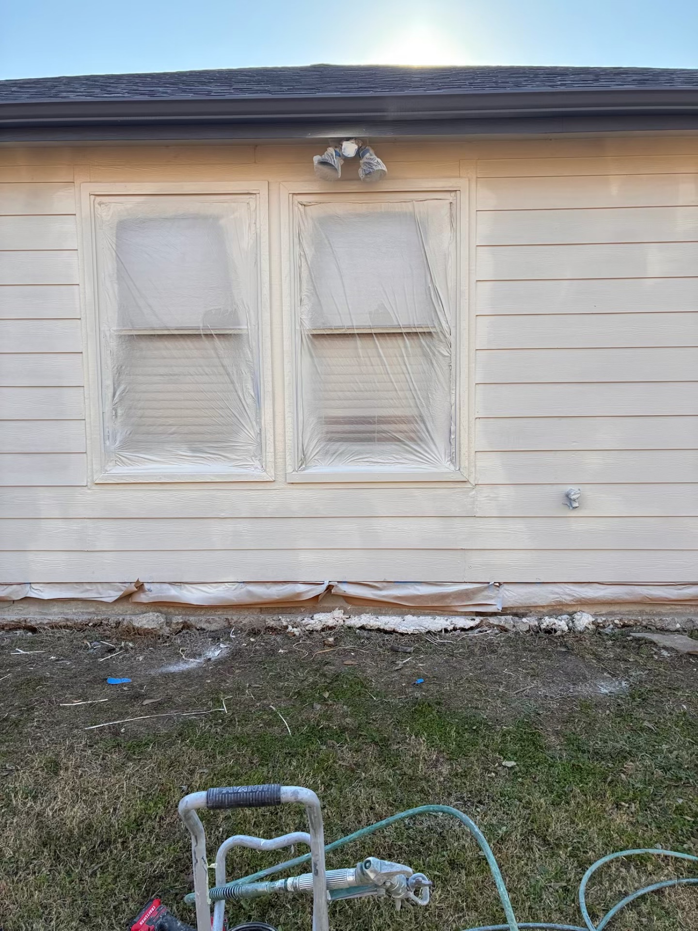 Home exterior siding prepped and masked before repaint