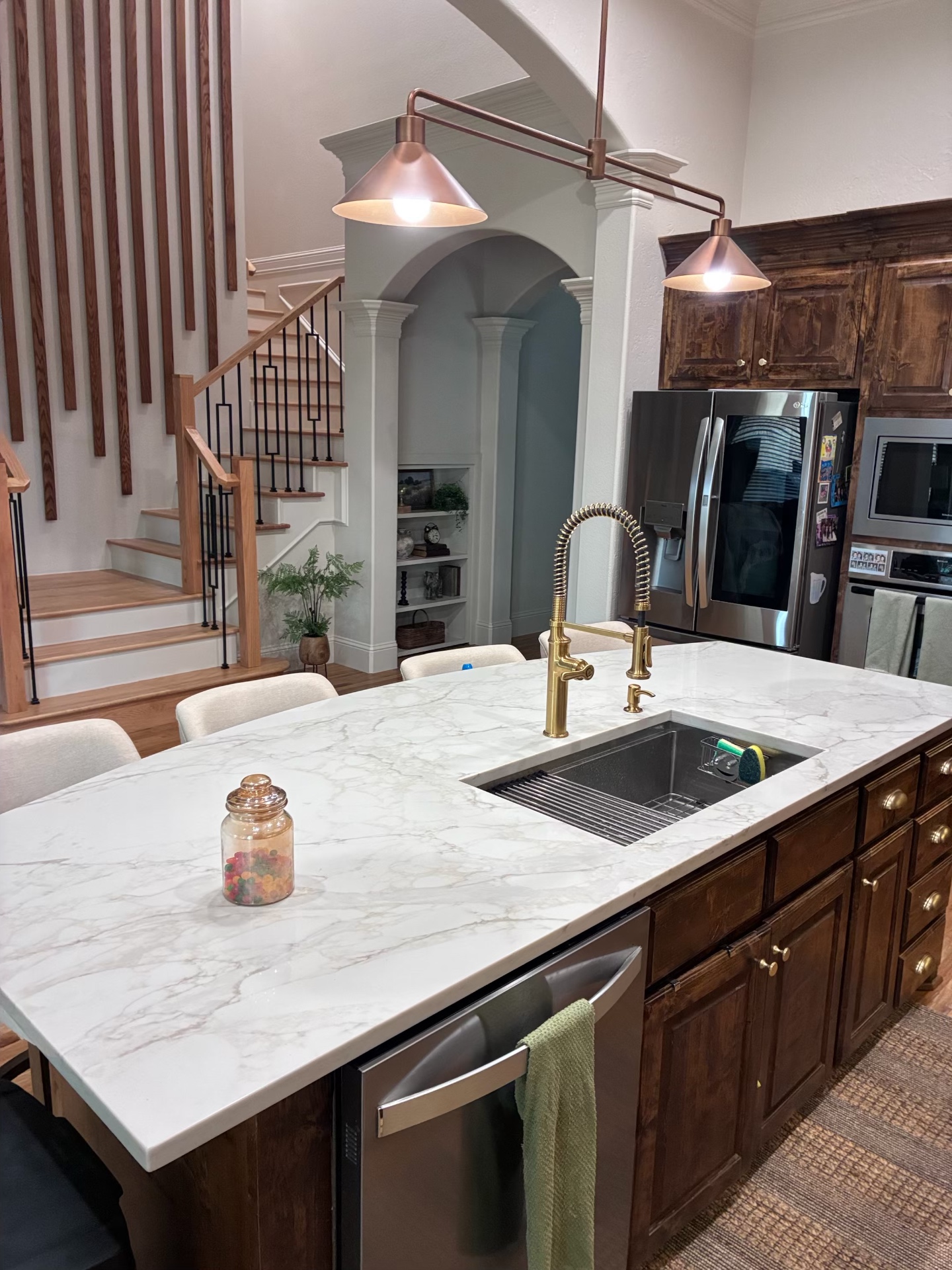 Large kitchen island with quartz countertop and copper pendant lighting
