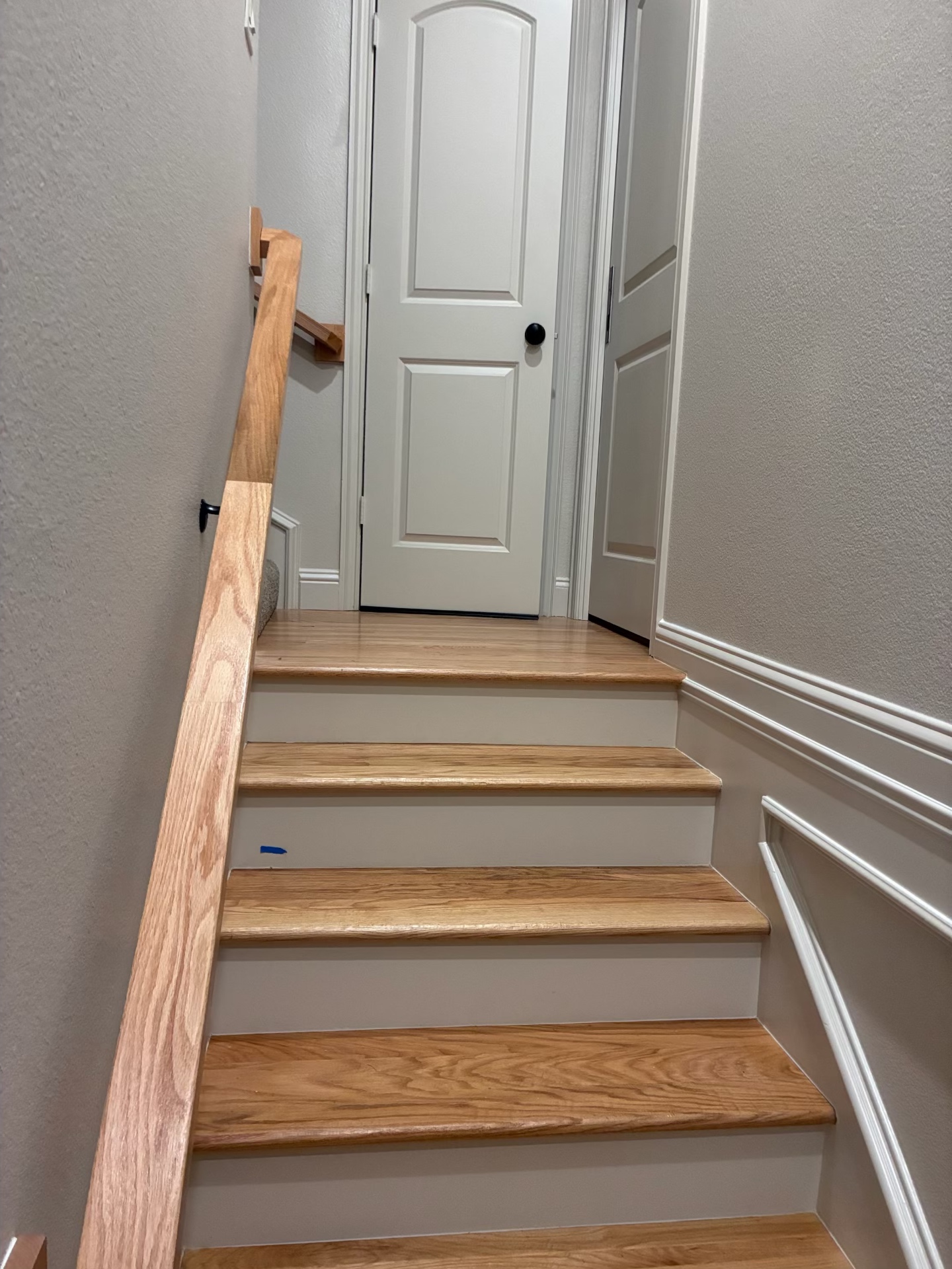 New solid oak stair treads installed with wood handrail