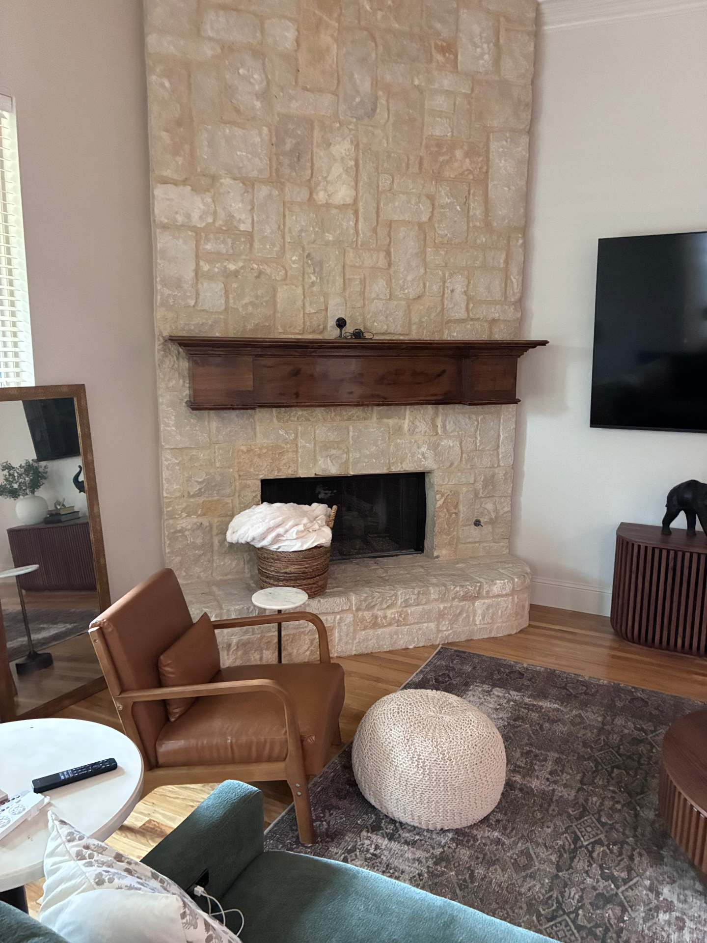 Floor-to-ceiling stone fireplace with reclaimed wood mantel