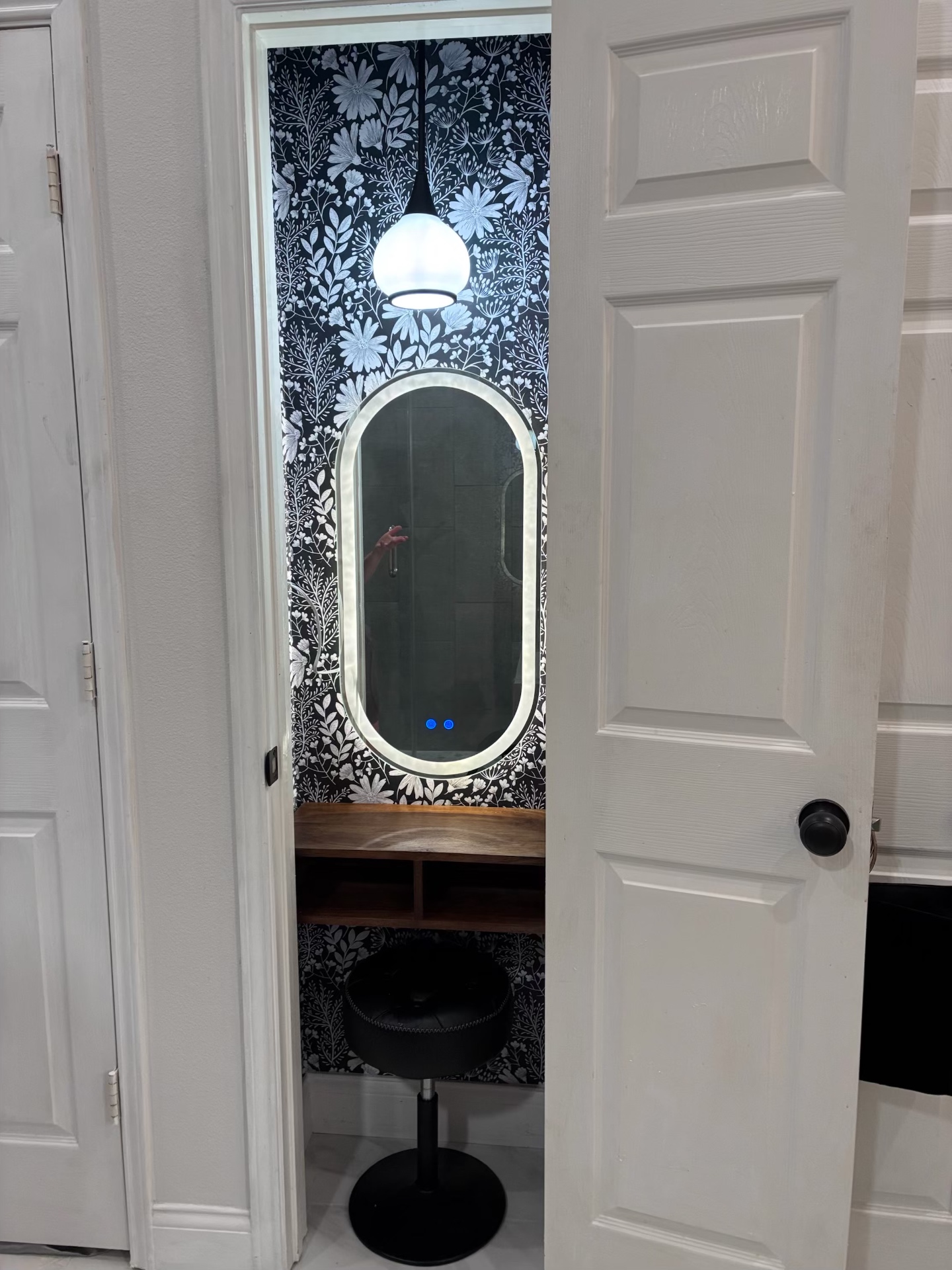 Built-in makeup vanity nook with floral wallpaper and LED mirror